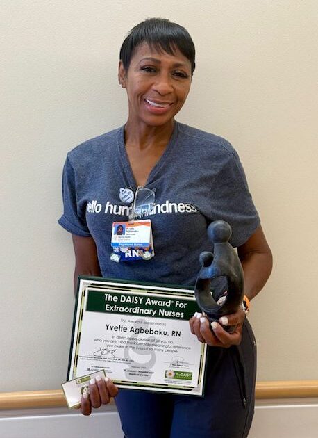 Barrow Nurse, Yvette Agbebaku, poses with her DAISY Award.