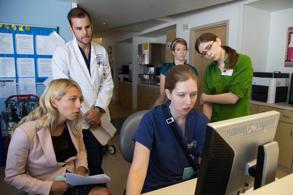 Barrow neurology residents review a patient's chart with Dr. Kamala Saha
