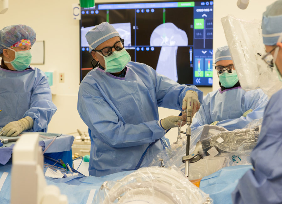 A photo of Dr. Juan Uribe using a surgical robot in the operating room
