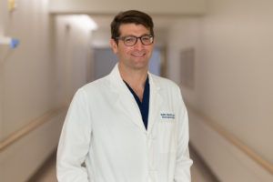 kaith almefty, md, wearing a lab coat in a hospital hallway