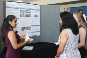 An undergraduate intern speaks with a faculty member