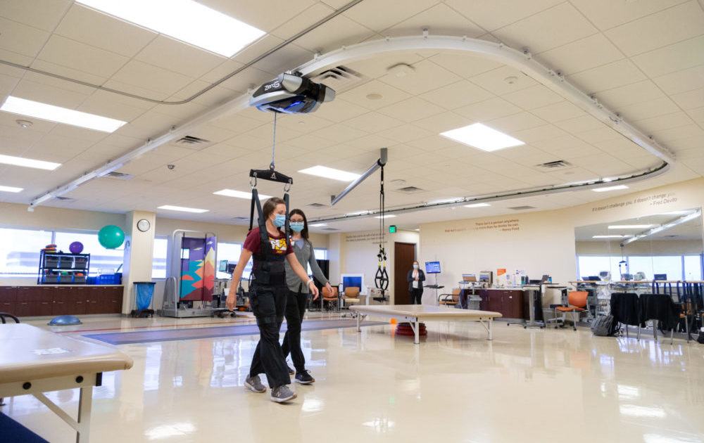 Staff demonstrate the ZeroG harness system in the Muhammad Ali Parkinson Center