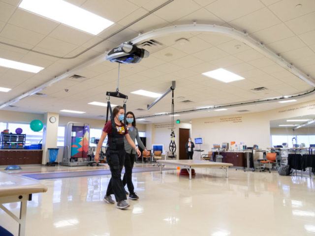 Staff demonstrate the ZeroG harness system in the Muhammad Ali Parkinson Center