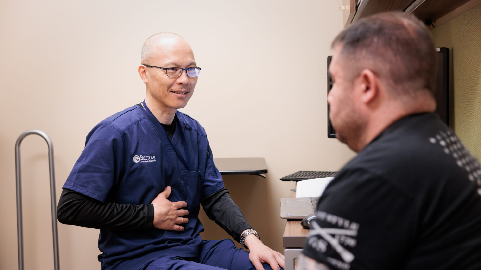 neuro-endocrinologist kevin yuen consults with a patient in an exam room