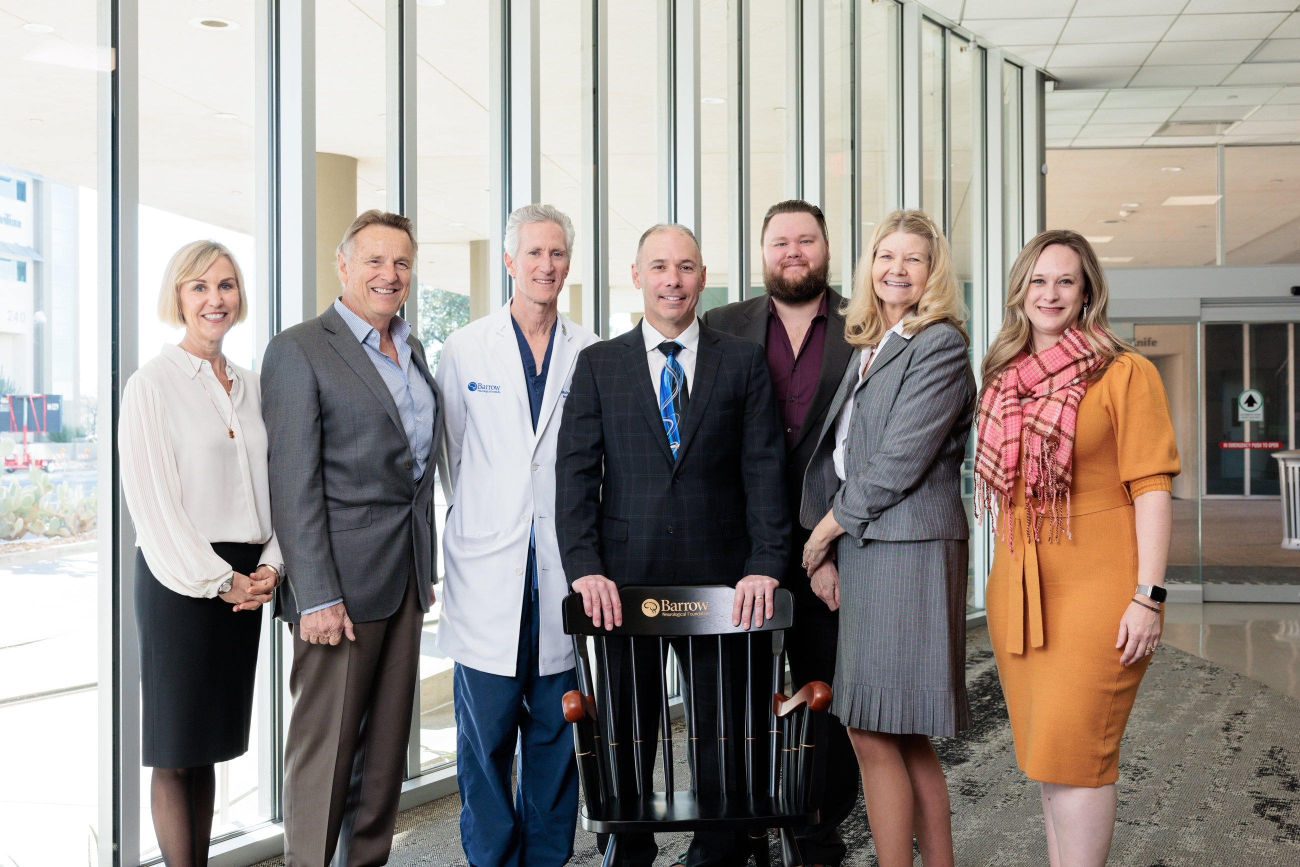 Dr. Racette poses with his chair, surrounded by a group.