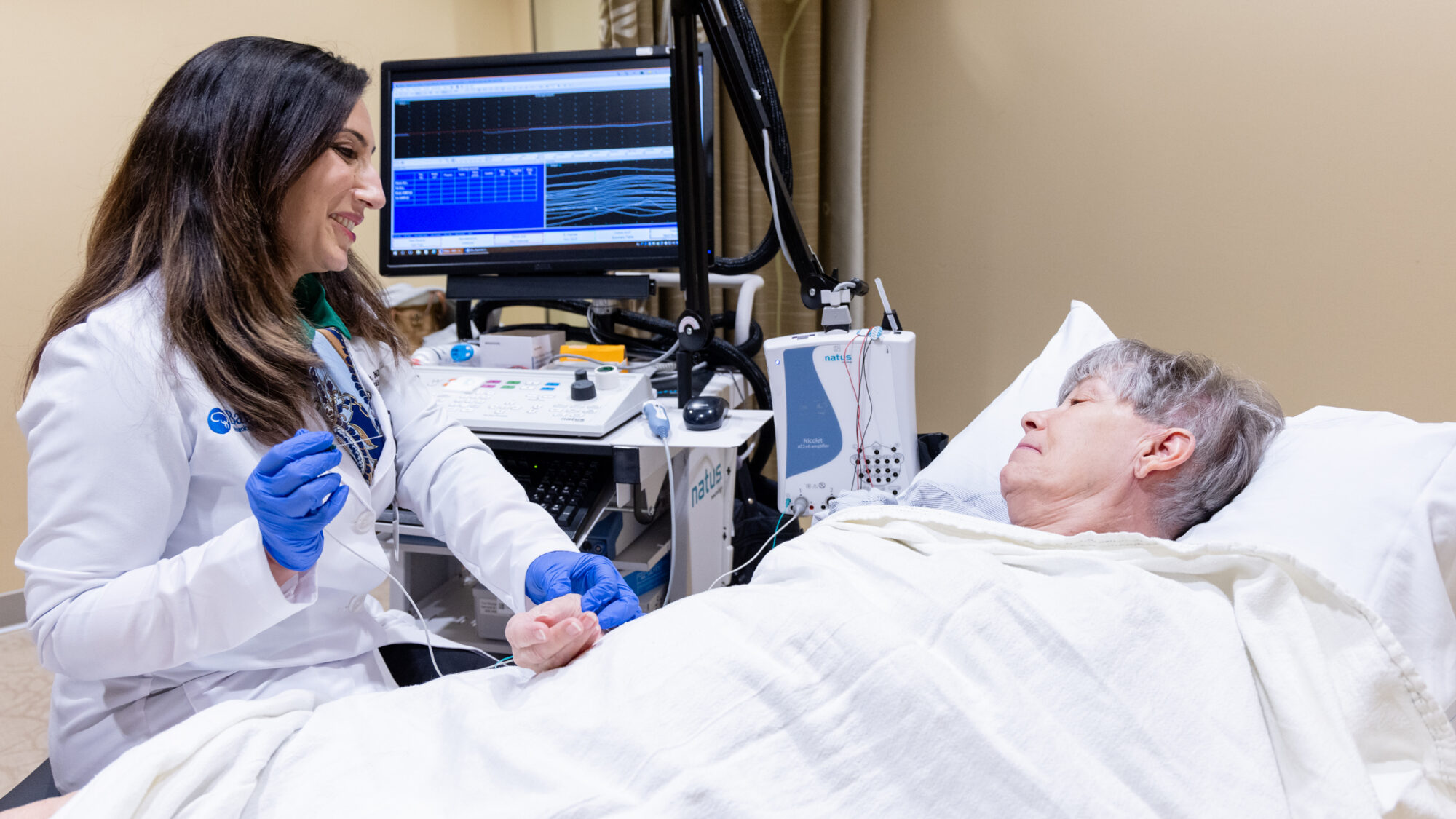 Neurologist Ayushi Chugh conducts an EMG exam on a patient in a procedure room at the Gregory W. Fulton ALS and Neuromuscular Disease Center.