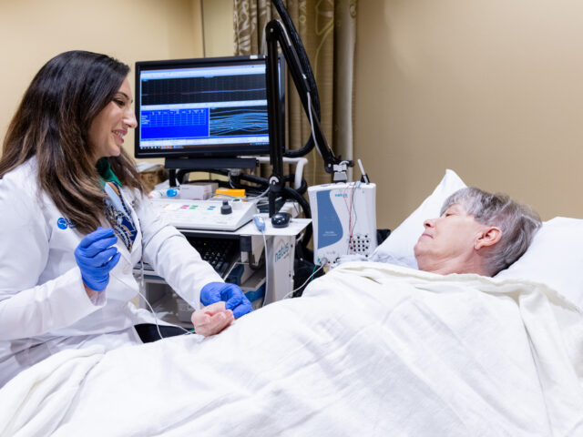 Neurologist Ayushi Chugh conducts an EMG exam on a patient in a procedure room at the Gregory W. Fulton ALS and Neuromuscular Disease Center.