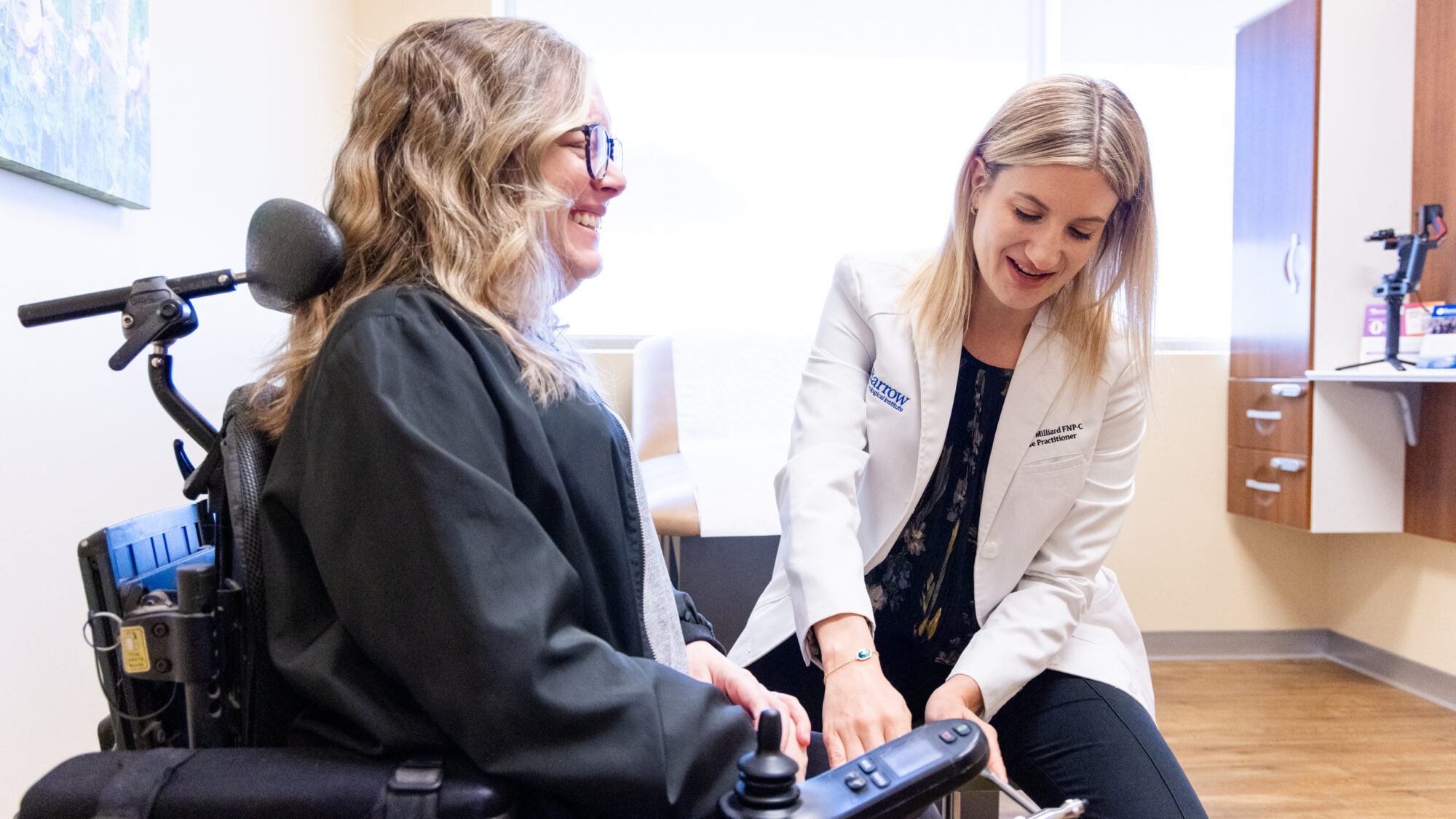 Nurse practitioner Jourdan Milliard examines a female ALS patient in a motorized wheelchair in an exam room at Barrow Neurological Institute in the Gregory W. Fulton ALS and Neuromuscular Disease Center.