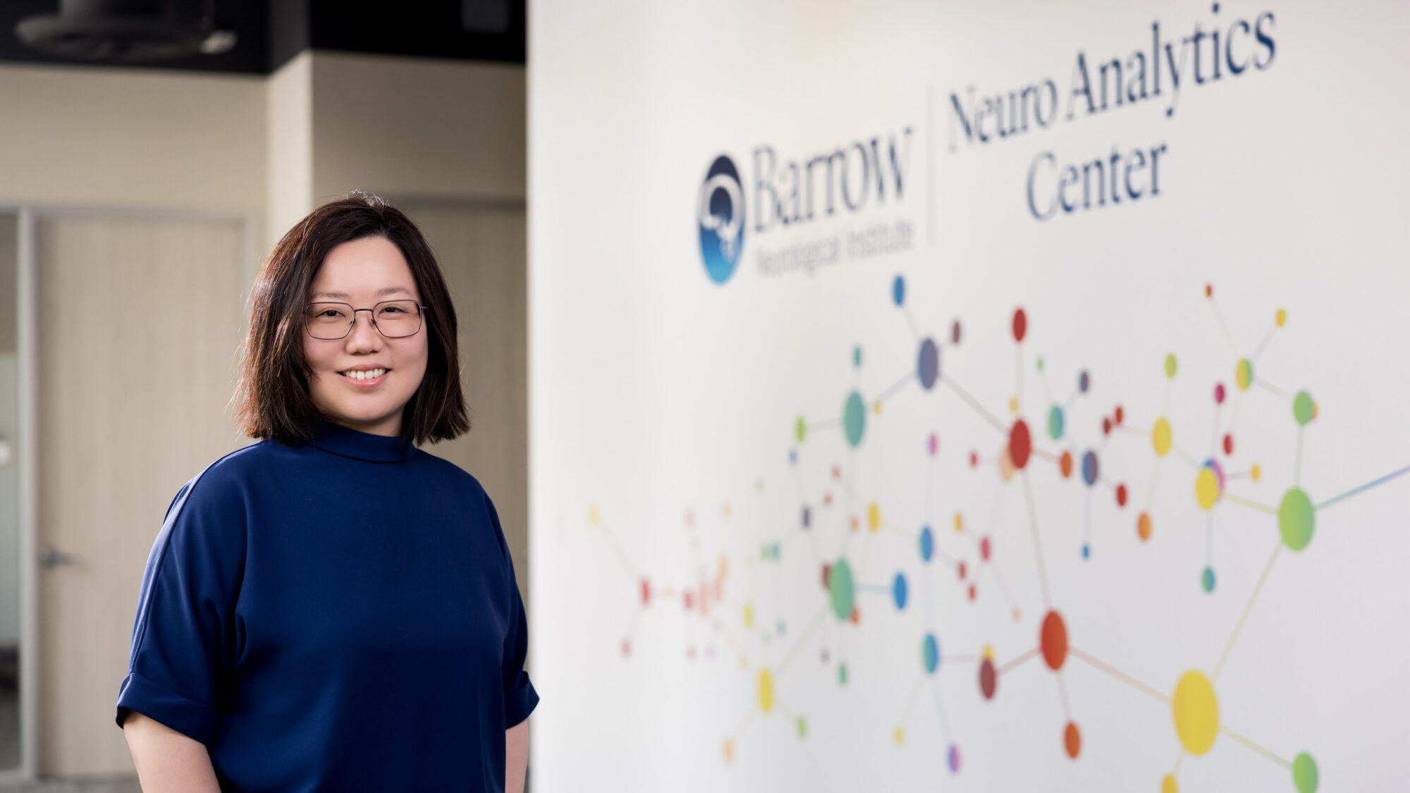 Portrait of Dr. Chia-Ling Phuah in front of the Barrow Neuro Analytics Center signage