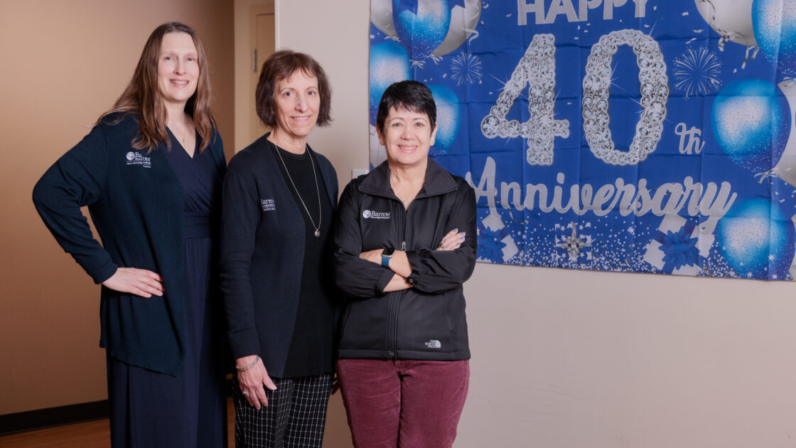 CTN leaders stand in front of a banner at CTN that says "Happy 40th Anniversary"
