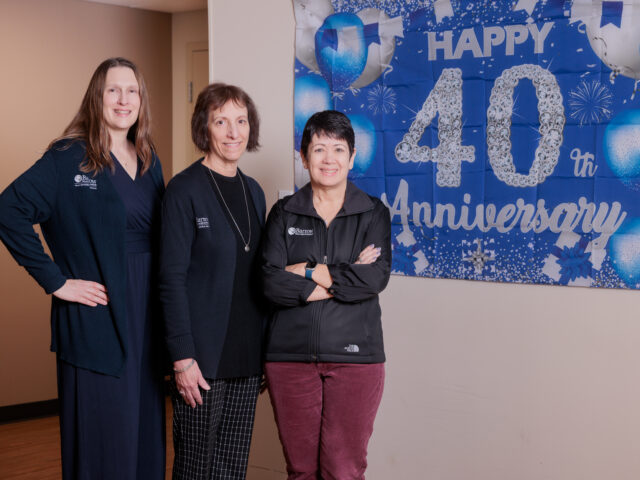 CTN leaders stand in front of a banner at CTN that says "Happy 40th Anniversary"