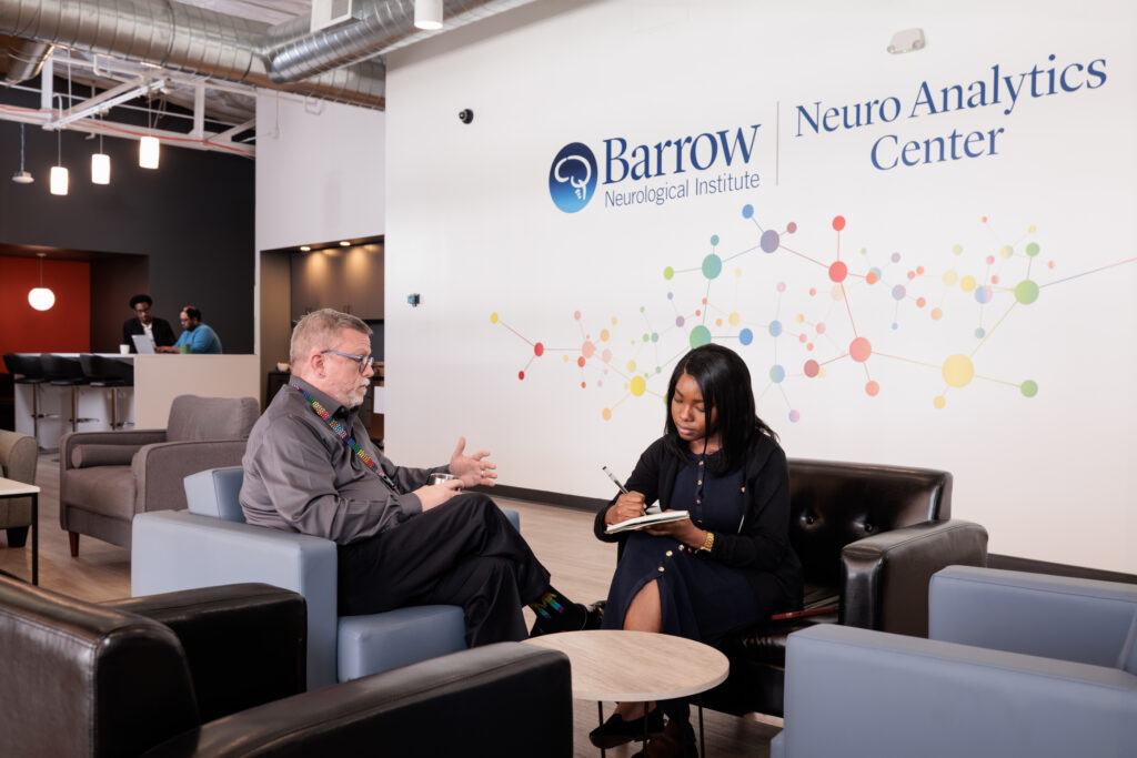 Two people having a discussion in the Barrow Neuro Analytics Center lobby