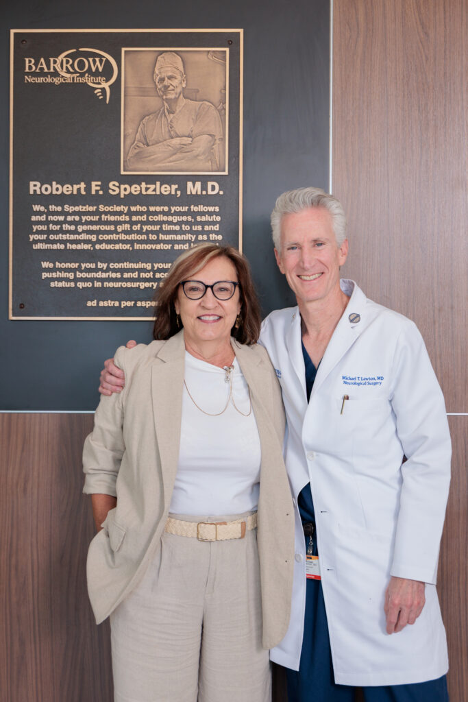 OR nurse Carol Blazier and Barrow President and CEO Dr. Michael T. Lawton with a plaque dedicated to former President and CEO Dr. Robert Spetzler