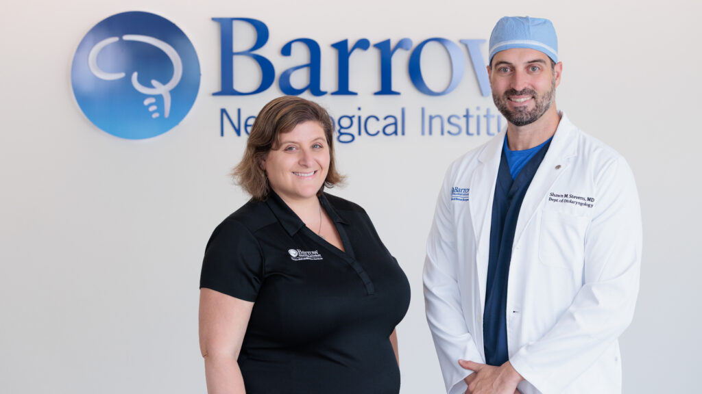 ENT surgeon Dr. Shawn Stevens and speech therapist Carolyn Abraham pose for a photo in front of a wall with the Barrow logo.