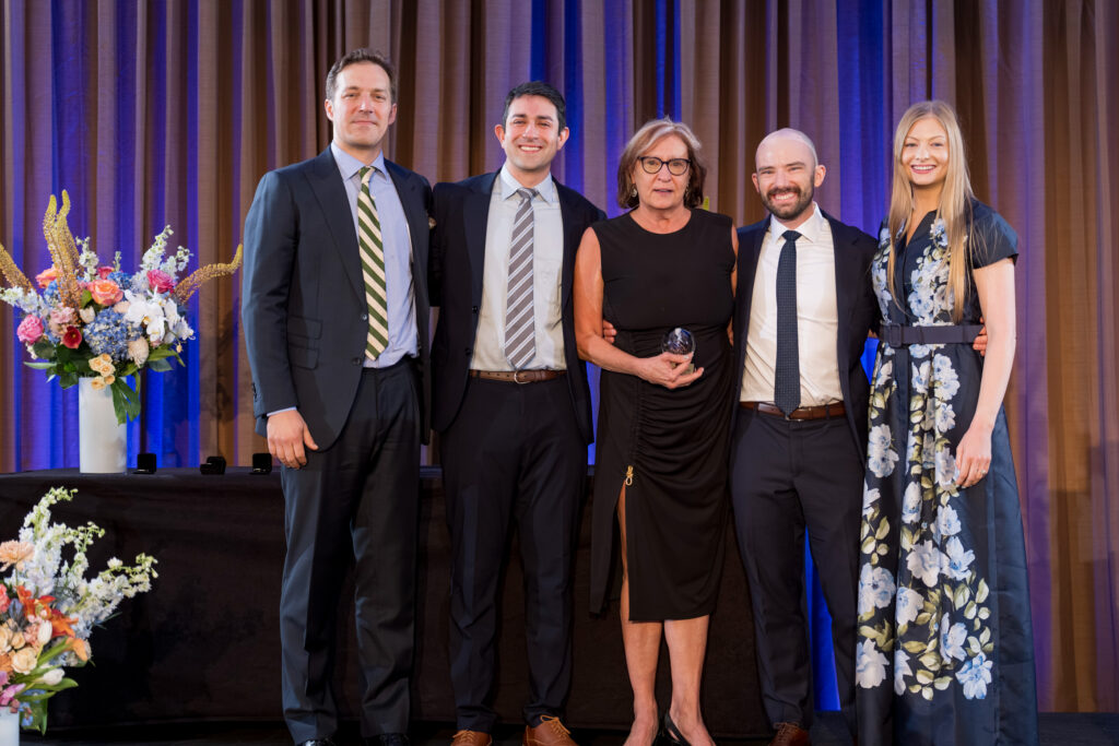 Barrow OR nurse Carol Blazier celebrates her retirement with the graduating class of neurosurgery residents on stage at their graduation ceremony