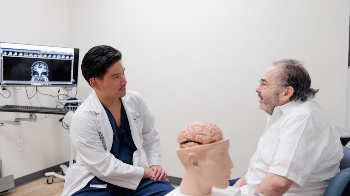 Dr. Yang speaks to patient George Zapien in his clinic at Barrow