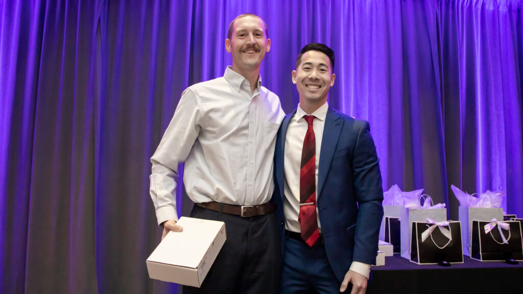 Dr. Bryan Franzen onstage accepting his award from a graduating resident