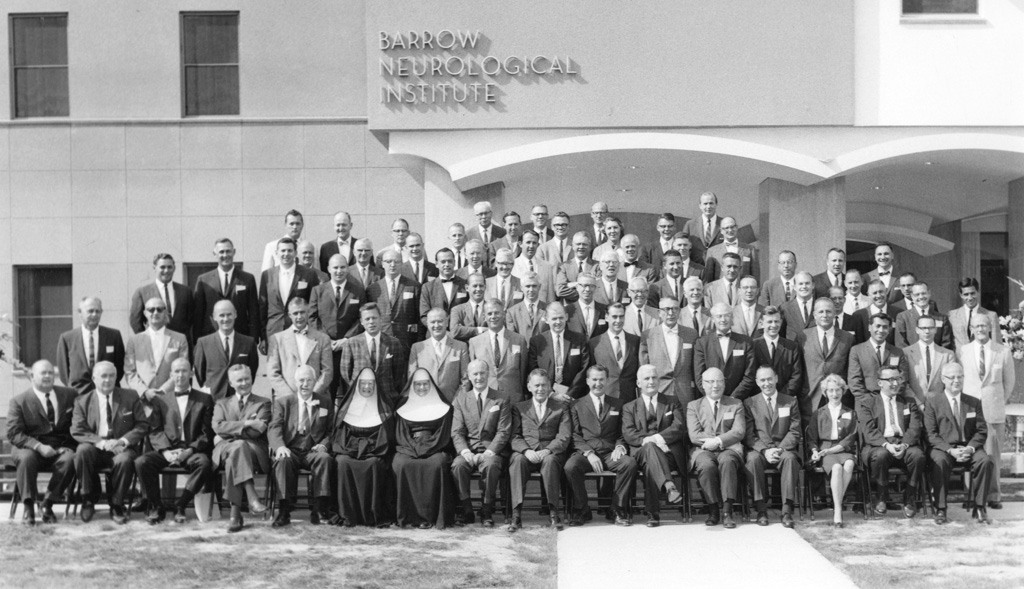 A black and white photo of staff in front of the original Barrow Neurological Institute building