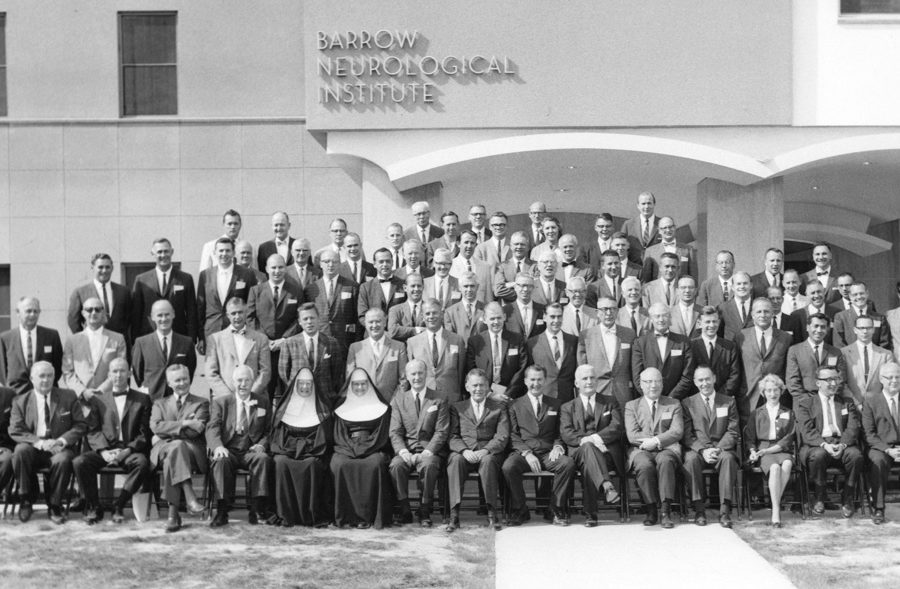 A black and white photo of staff in front of the original Barrow Neurological Institute building