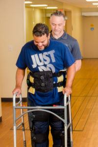 Kevin Jimenez walks with the Indego under the supervision of Barrow physical therapist Al Biemond.