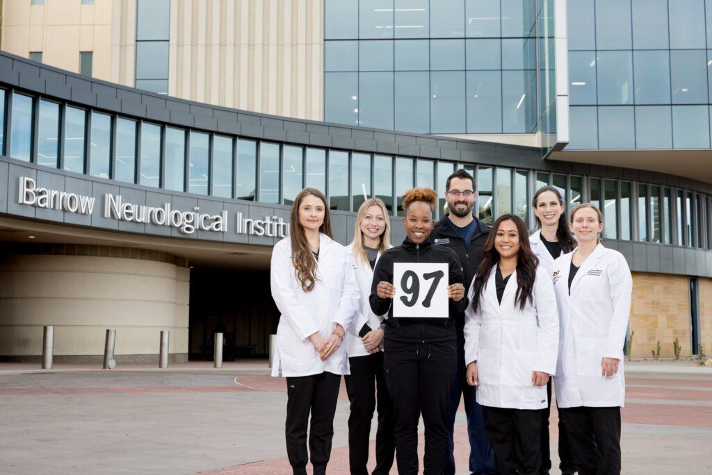 photo of doctor shawn stevens and the cochlear implant team standing outside of the barrow neuroplex to commemorate their 97th cochlear implant surgery