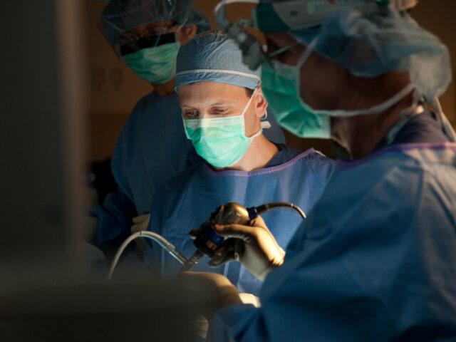 pituitary surgeon andrew little performs surgery in an operating room