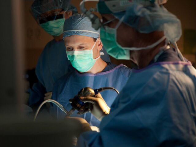 pituitary surgeon andrew little performs surgery in an operating room