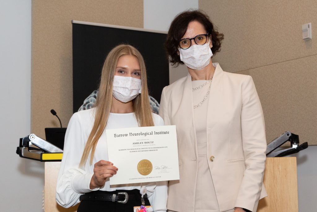 Ashley Holtz is holding a completion certificate and standing next to Dr. Rita Sattler