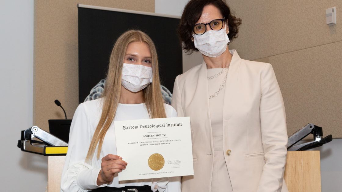 Ashley Holtz is holding a completion certificate and standing next to Dr. Rita Sattler