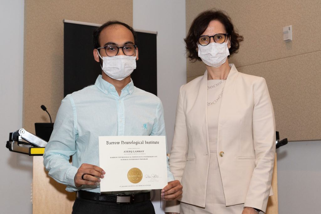 Ateeq Lambay is holding a completion certificate and standing next to Dr. Rita Sattler