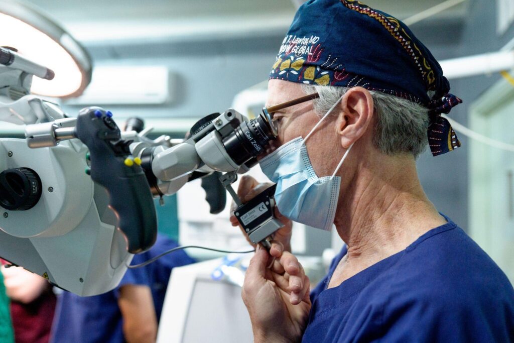 Dr. Michael T. Lawton affixes a new donated mouthpiece to the surgical microscope in the operating room at KCMC in Tanzania.