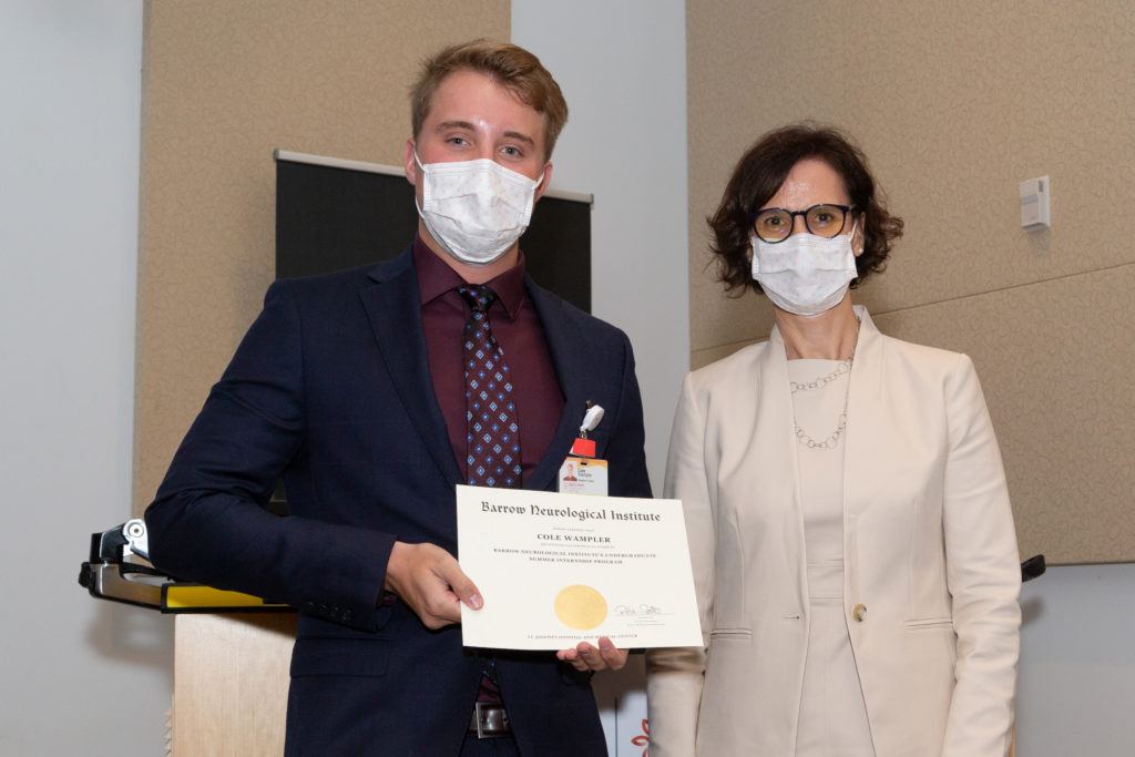 Cole Wampler holding a completion certificate and standing next to Dr. Rita Sattler