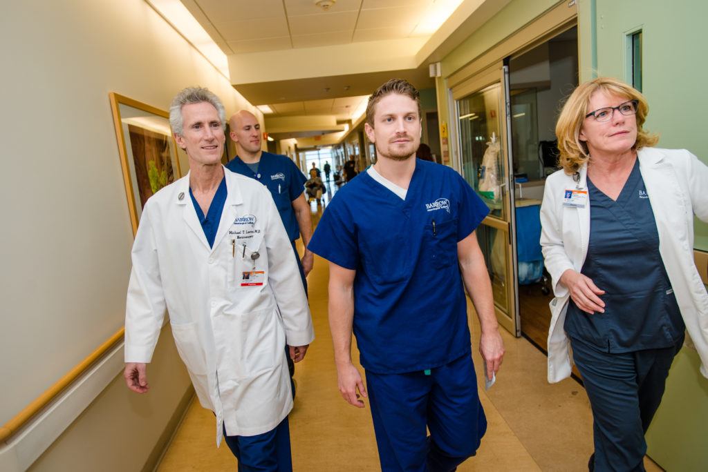 Dr. Michael Lawton and Virginia Prendergast walk through the hallway with other staff.