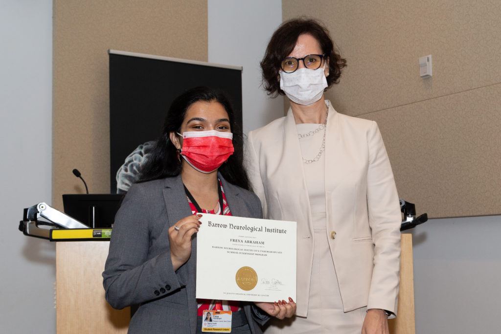 Picture of Freya Abraham holding a completion certificate and standing next to Dr. Rita Sattler