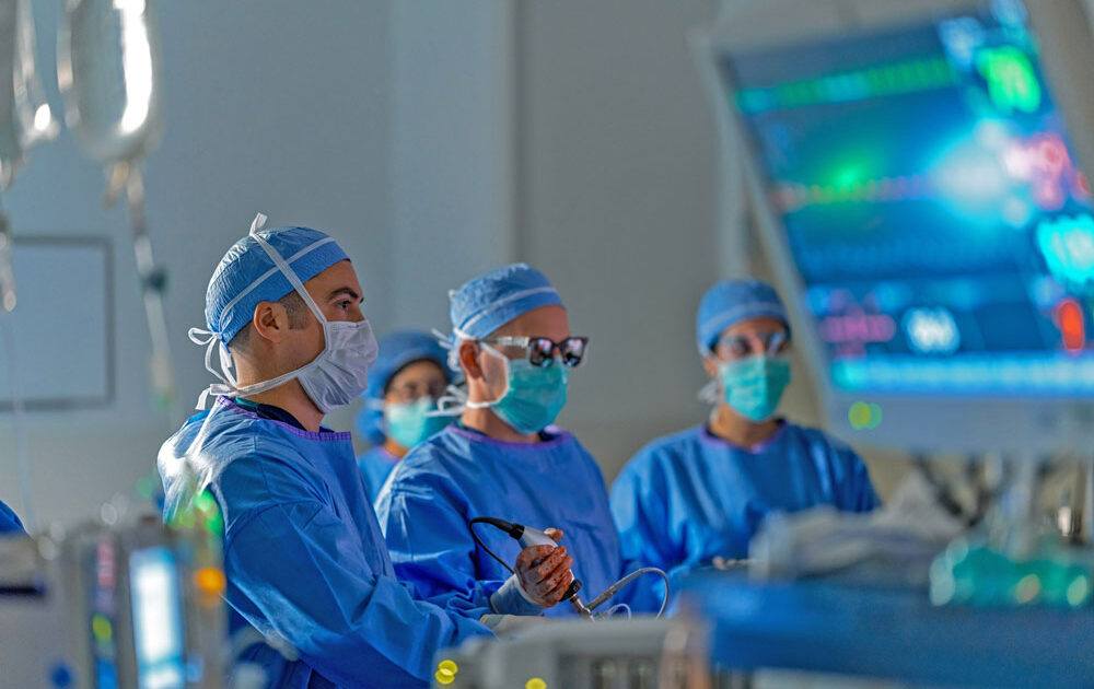 Dr. Griffin Santarelli is pictured with a team in the operating room. They are performing surgery.