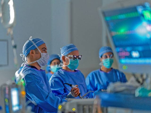 Dr. Griffin Santarelli is pictured with a team in the operating room. They are performing surgery.