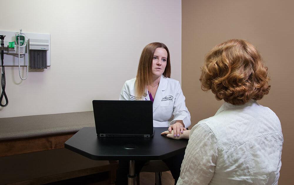 A doctor speaking with her patient at a table