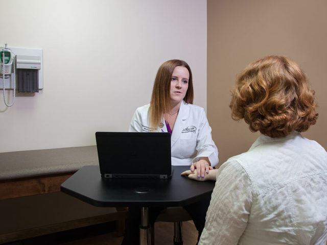 A doctor speaking with her patient at a table