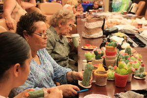 A woman knits cacti decorations at the Muhammad Ali Parkinson Center