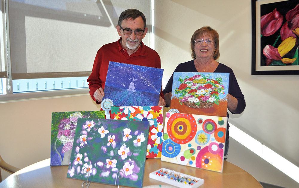 John and Karen O'Donnell pose with their paintings