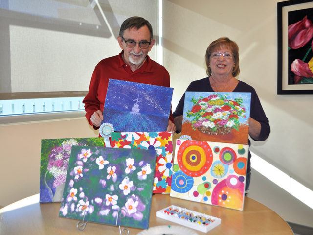 John and Karen O'Donnell pose with their paintings