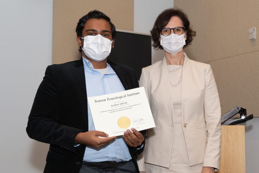 Kamal Shaik holding a completion certificate and standing next to Dr. Rita Sattler