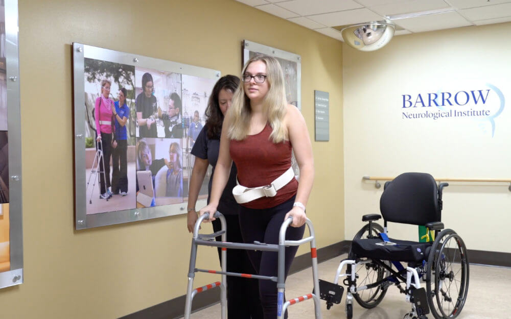 Kara Dunn walks with assistance at Barrow after being paralyzed by Guillain-Barré syndrome