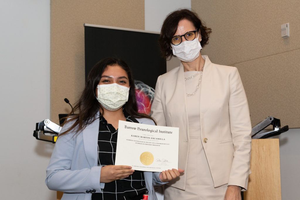 Karen Martin-Escamilla holding a completion certificate and standing next to Dr. Rita Sattler