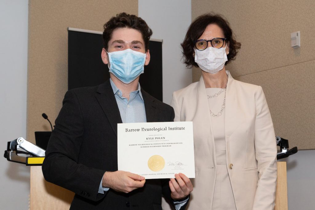 Kylen Pole holding a completion certificate and standing next to Dr. Rita Sattler