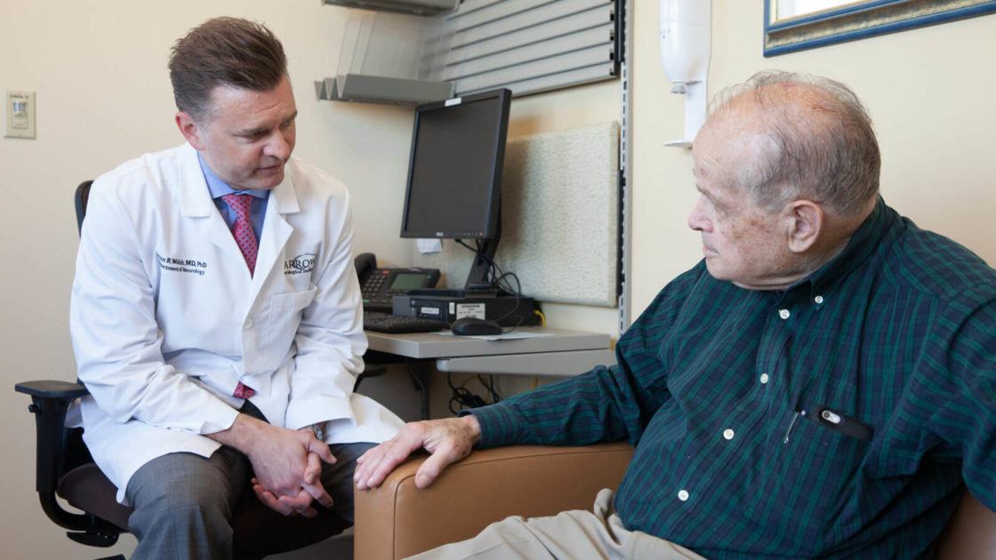 Doctor sitting with his elderly patient