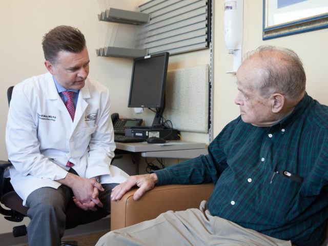 Doctor sitting with his elderly patient