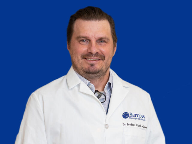 Photo of Dr. Manfredsson in a white lab coat on a blue background