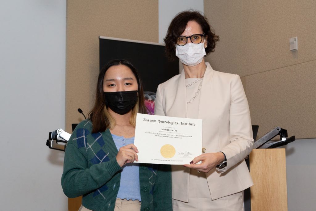 Minha Kim holding a completion certificate and standing next to Dr. Rita Sattler
