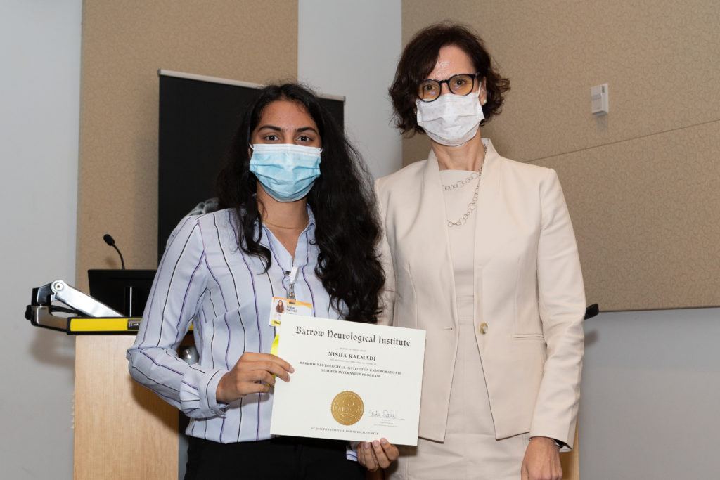 Nisha Kalmadi holding a completion certificate and standing next to Dr. Rita Sattler